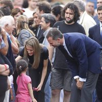 Los Príncipes Felipe y Letizia saludan a una niña en el lugar del accidente ferroviario