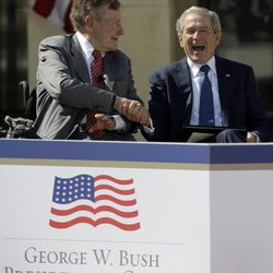 George Bush da la mano a su sonriente hijo George W. Bush