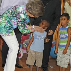 La Reina Sofía acaricia a un niño durante su visita a los proyectos de Cáritas Mallorca