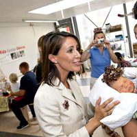 Marie de Dinamarca con un bebé en su visita al Hospital de Odense