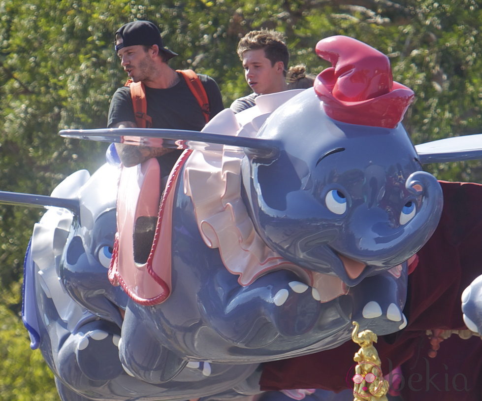 David Beckham con su hijo Brooklyn en un Dumbo volador en Disneyland