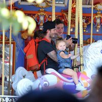 David Beckham con sus hijos Brooklyn y Harper Seven en los caballitos de Disneyland