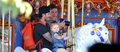 David Beckham con sus hijos Brooklyn y Harper Seven en los caballitos de Disneyland