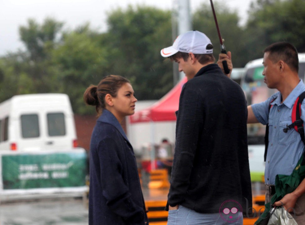 Ashton Kutcher y Mila Kunis tapados de la lluvia en China