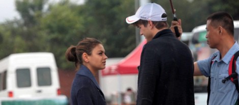 Ashton Kutcher y Mila Kunis tapados de la lluvia en China