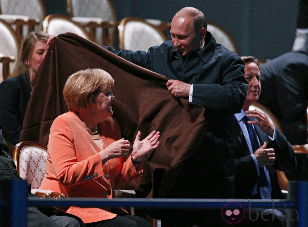 Vladimir Putin cubriendo a Angela Merkel con una manta en San Petersburgo