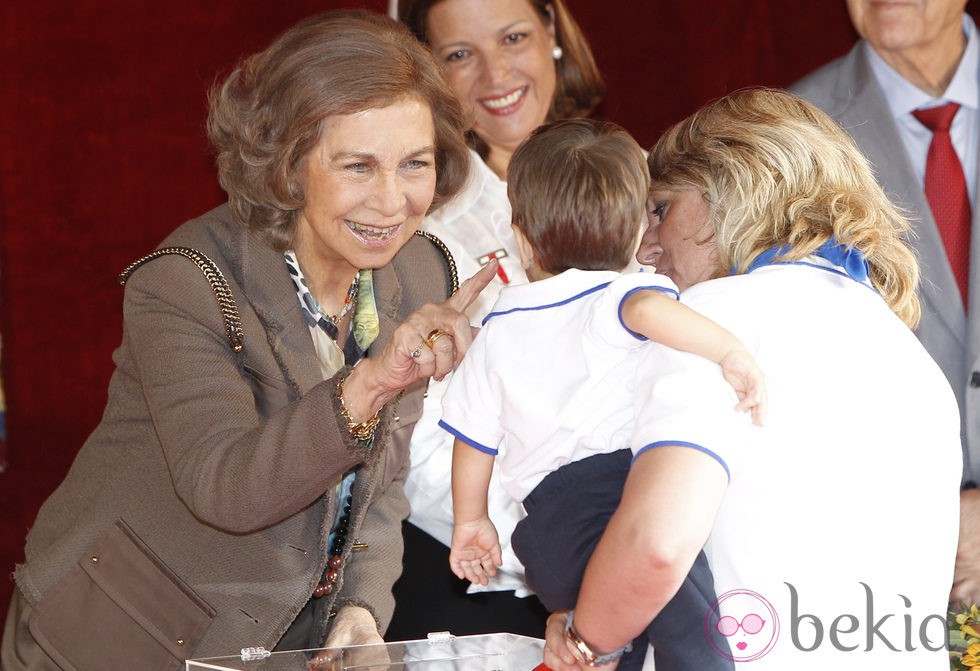 La Reina Sofía hace una carantoña a un niño en el Día de la Banderita 2013