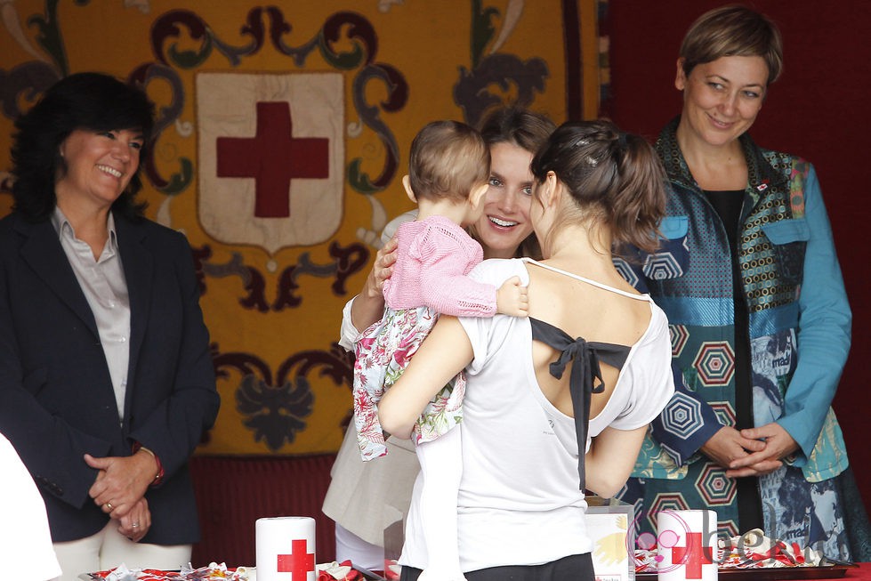 La Princesa de Asturias, cariñosa con un bebé en el Día de la Banderita 2013