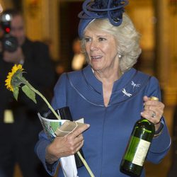 Camilla Parker con una botella de vino y un girasol en una misa en la Abadía de Westminster