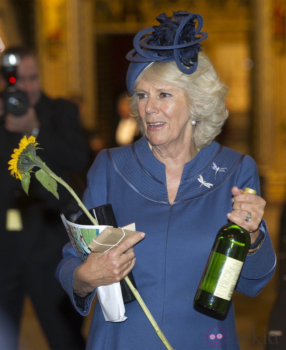 Camilla Parker con una botella de vino y un girasol en una misa en la Abadía de Westminster