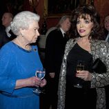 La Reina Isabel charla con Joan Collins en una recepción en Buckingham Palace