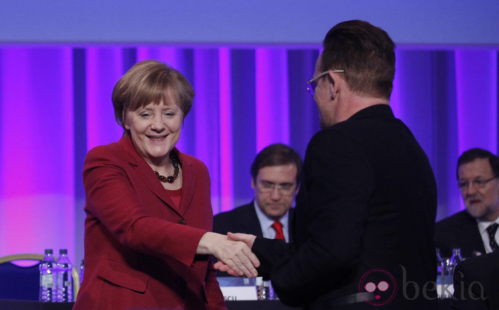 Bono saluda a Angela Merkel durante su intervención en el congreso del Partido Popular Europeo en Dublín