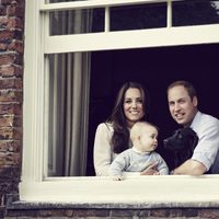 El Príncipe Guillermo y Kate Middleton posan con el Príncipe Jorge y un perro desde una ventana del Palacio de Kensington 