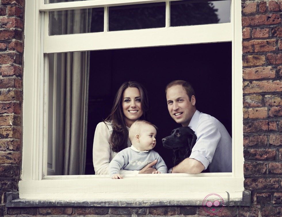 El Príncipe Guillermo y Kate Middleton posan con el Príncipe Jorge y un perro desde una ventana del Palacio de Kensington 