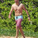 James Marsden en bañador caminando por una playa de Hawaii