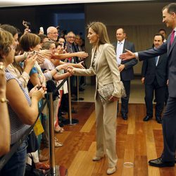 Los Príncipes Felipe y Letizia saludan a unos ciudadanos en la inauguración de una exposición