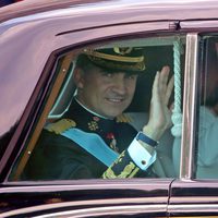 El Rey Felipe VI y la Reina Letizia saludan durante el recorrido hasta el Congreso de los Diputados