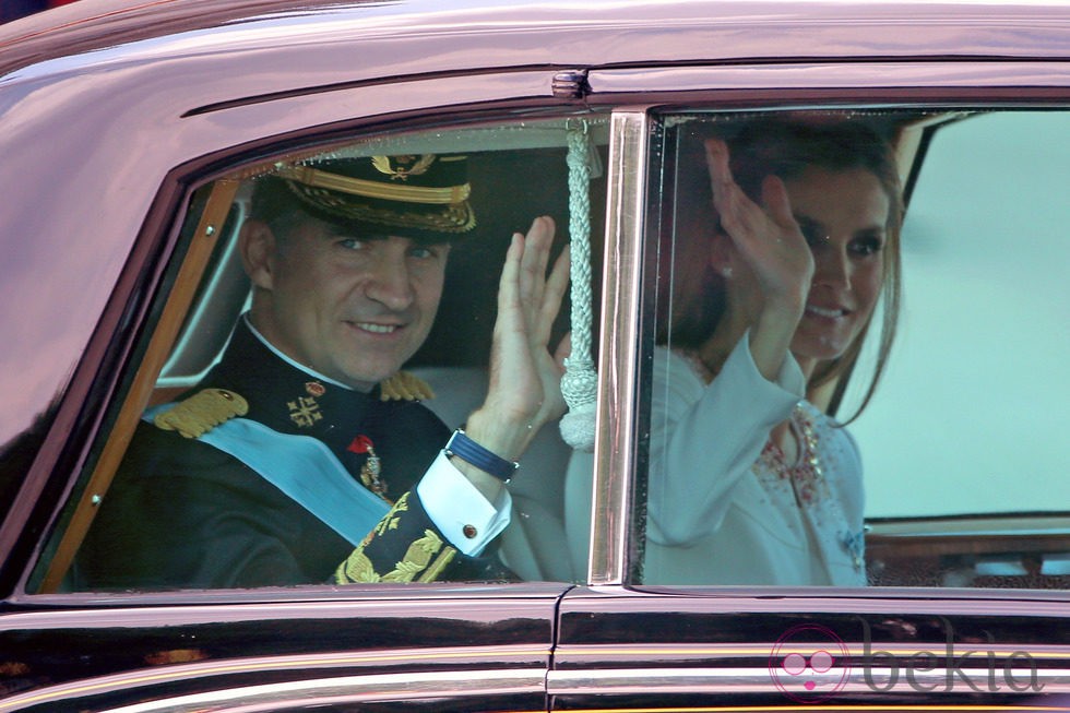 El Rey Felipe VI y la Reina Letizia saludan durante el recorrido hasta el Congreso de los Diputados