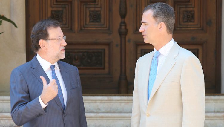 Mariano Rajoy y el Rey Felipe VI intercambian unas palabras en la entrada del Palacio de Marivent