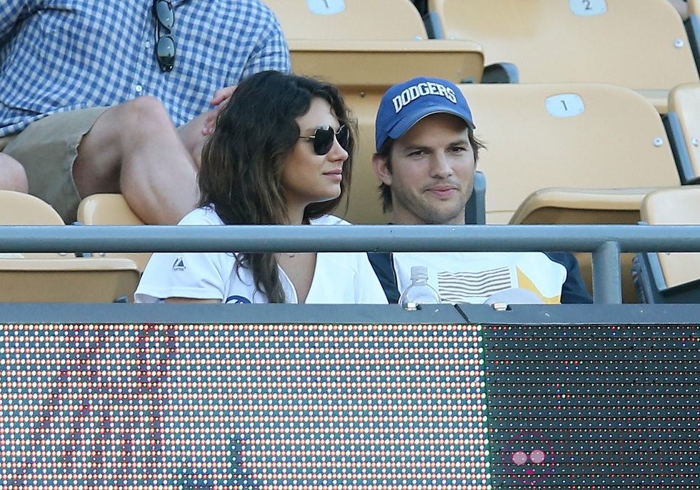 Ashton Kutcher y Mila Kunis en un partido de béisbol