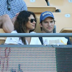 Ashton Kutcher y Mila Kunis en un partido de béisbol