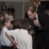 El Principe Guillermo con unos niños en la cena benéfica SkillForce