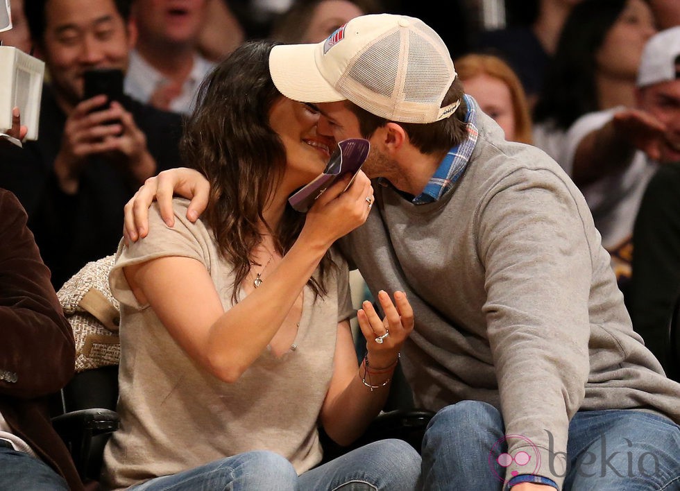 Mila Kunis y Ashton Kutcher se besan durante un partido de Los Angeles Lakers