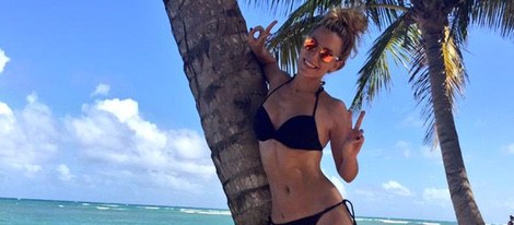 Edurne luce cuerpo en bikini en la playa junto a una palmera