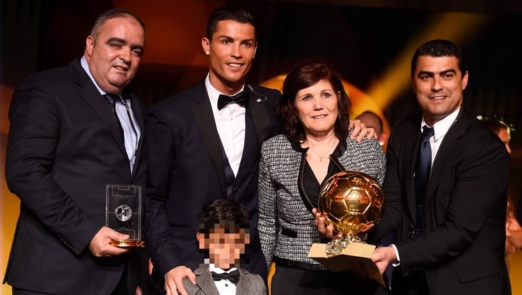 Cristiano Ronaldo posando con el Balón de Oro 2014 junto a su familia