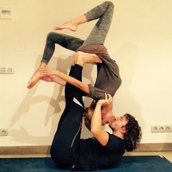 Carles Puyol y Vanesa Lorenzo practicando acroyoga mientras se dan un beso