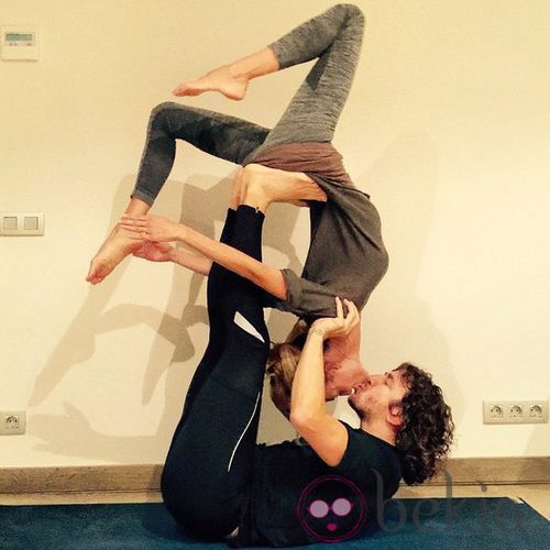 Carles Puyol y Vanesa Lorenzo practicando acroyoga mientras se dan un beso