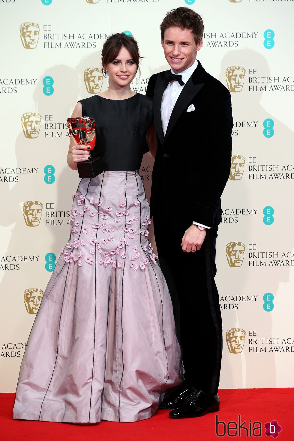 Felicity Jones y Eddie Redmayne posan con el premio a mejor película británica para 'La teoría del todo' en los Premios BAFTA 2015