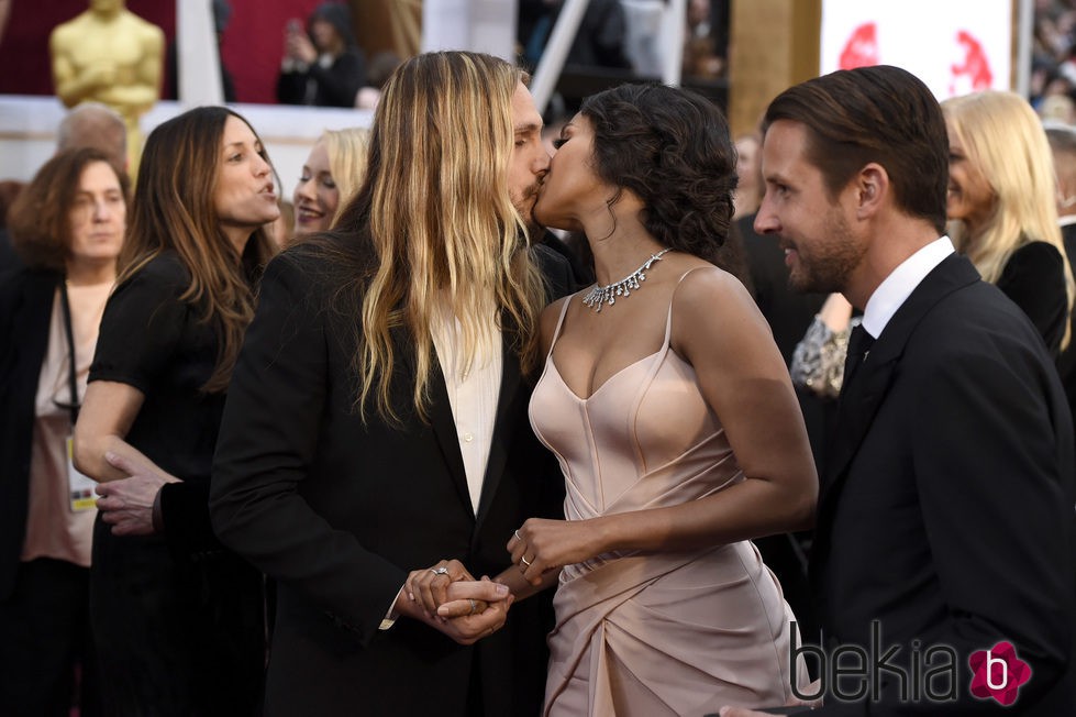 Zoe Saldaña y Marco Perego besándose en la alfombra roja de los Oscar 2015