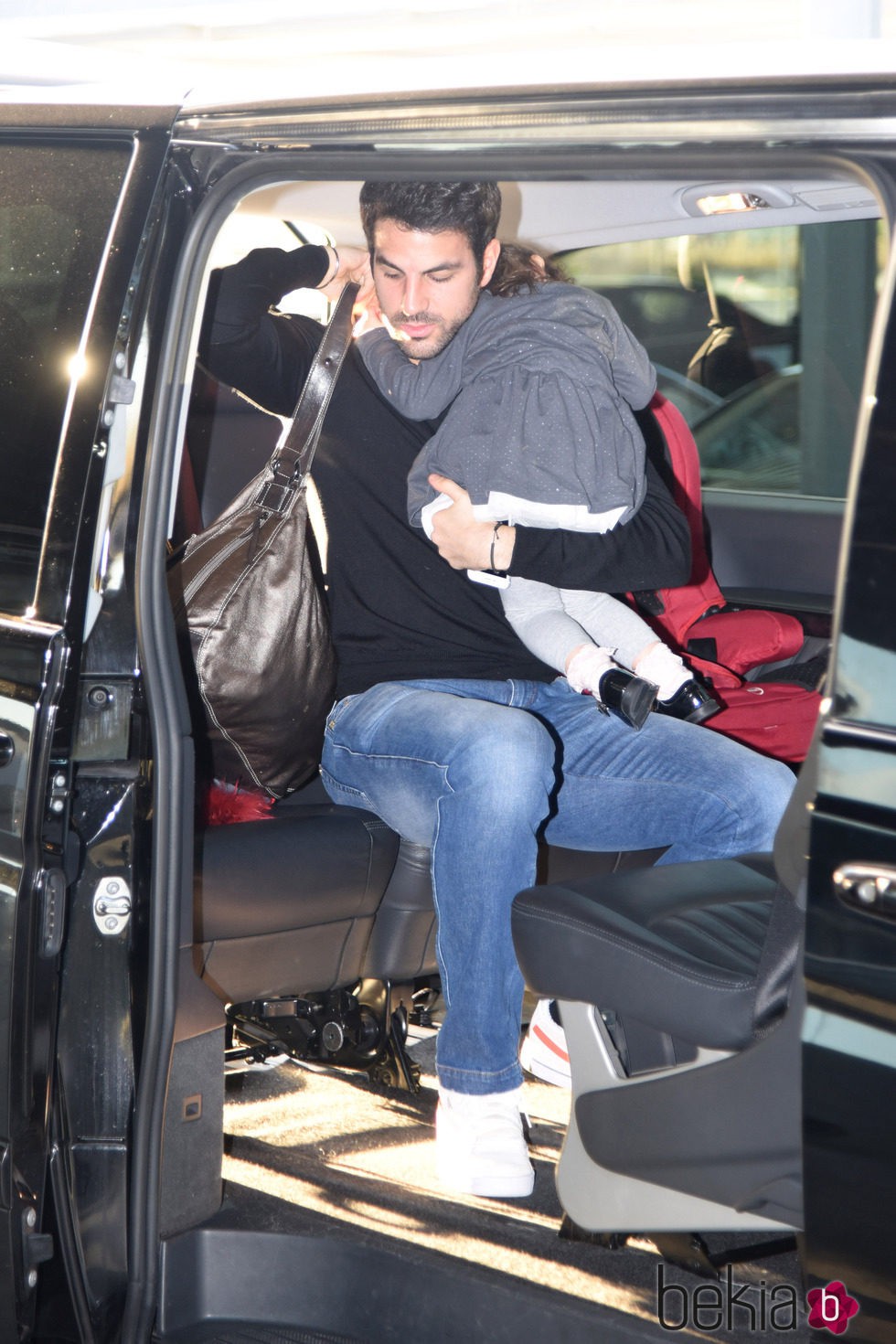 Cesc Fábregas con su hija Lia en brazos en el aeropuerto de Barcelona