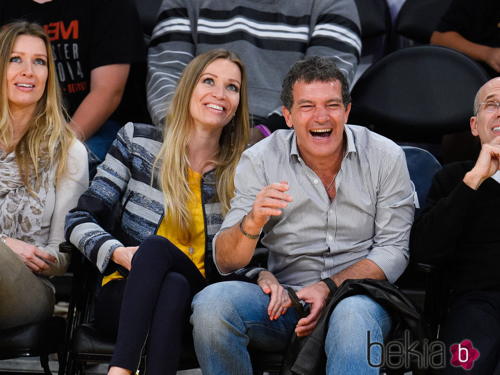 Antonio Banderas se ríe con Barbara y Nicole Kimpel en un partido de baloncesto 