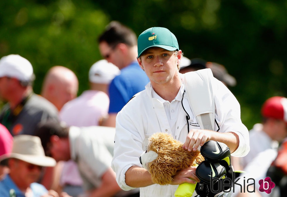 Niall Horan haciendo de caddie para Rory Mcllroy