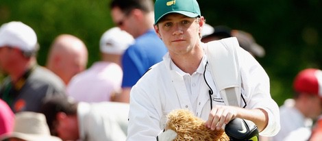 Niall Horan haciendo de caddie para Rory Mcllroy