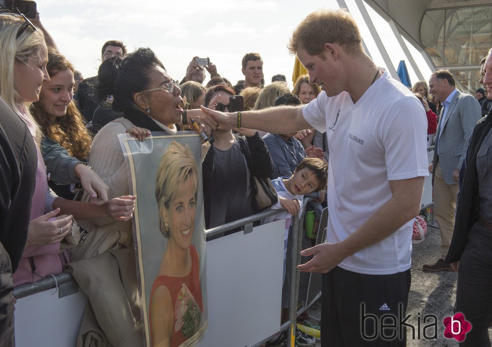 El Príncipe Harry saluda a una fan neozelandesa con una foto gigante de su madre