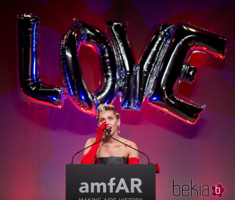 Miley Cyrus muy emocionada recogiendo su premio en la gala amfAR Inspiration de Nueva York 2015