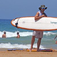 Hugo Silva con una tabla de surf en Cádiz