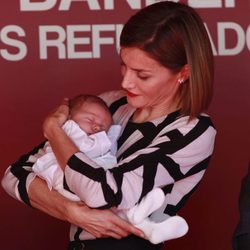 La Reina Letizia con un bebé en brazos en el Día de la Banderita 2015