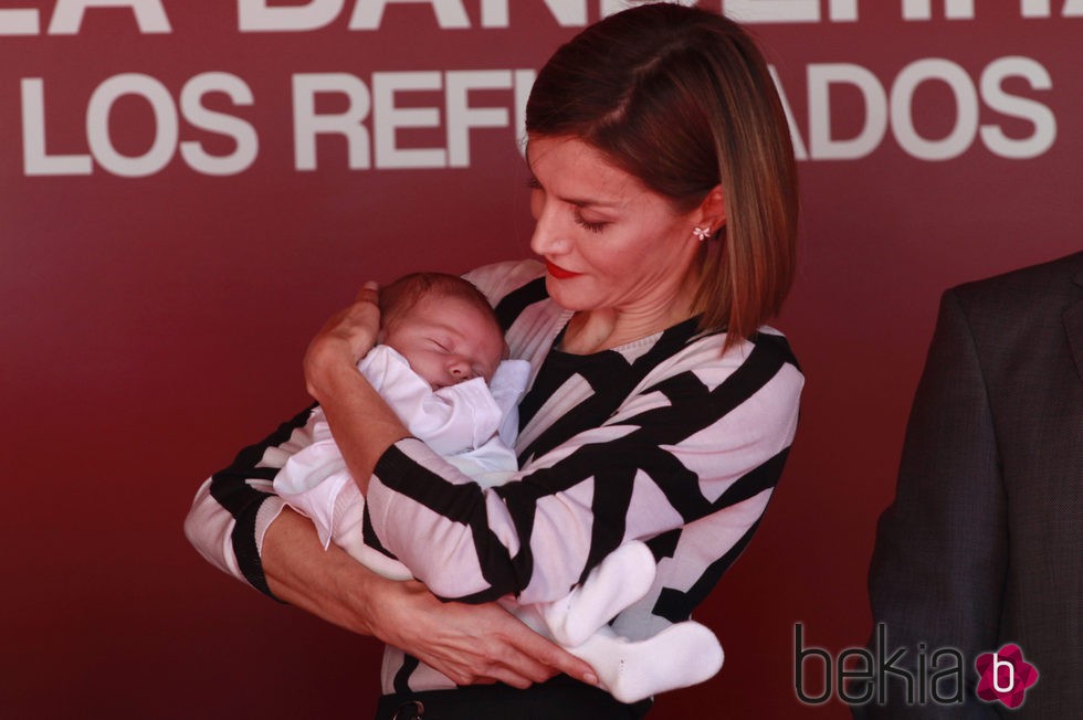 La Reina Letizia con un bebé en brazos en el Día de la Banderita 2015