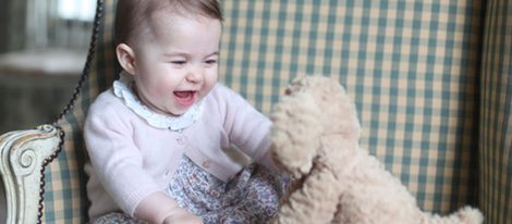 La Princesa Carlota de Cambrigde muy sonriente jugando con un oso de peluche