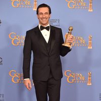 Jon Hamm posando con su premio de los Globos de Oro 2016