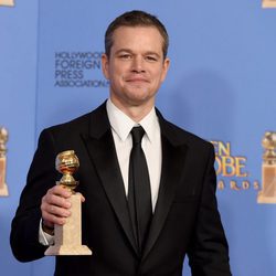 Matt Damon posando con su premio de los Globos de Oro 2016