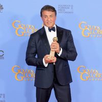 Sylvester Stallone posando con su premio en los Globos de Oro 2016