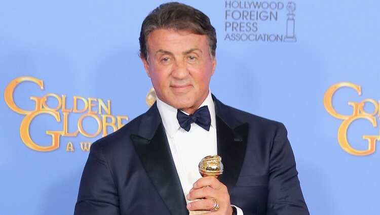 Sylvester Stallone posando con su premio en los Globos de Oro 2016