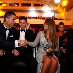 Cristiano Ronaldo y Antonella Roccuzzo se saludan ante la mirada de Leo Messi en la entrega del Balón de Oro 2015