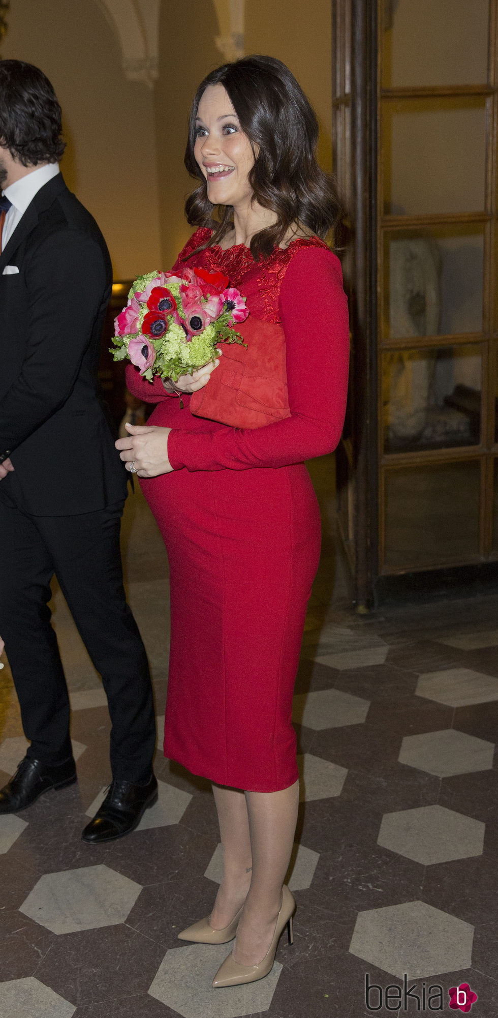 Sofia Hellqvist luciendo embarazo con un ajustado vestido rojo