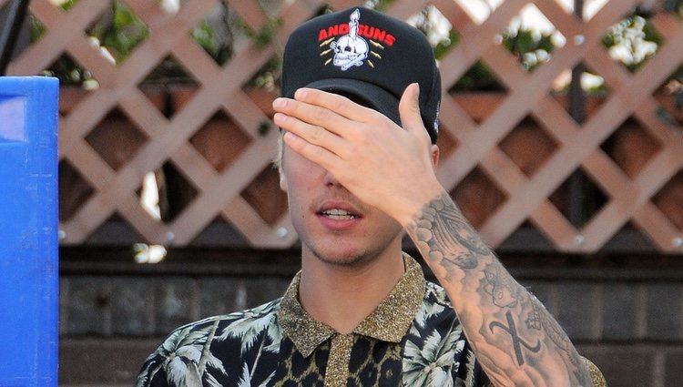 Justin Bieber tapándose la cara